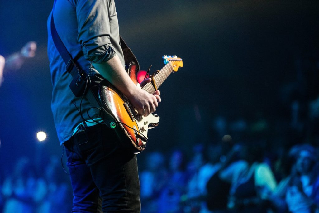 男性がステージでギターを演奏している画像