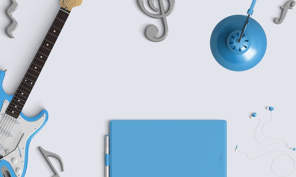 青色のギターやパソコンが並んでいる可愛らしい画像