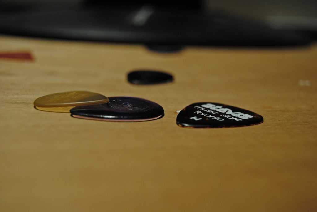 ギターやベースを演奏する際に使うピックが机の上に置かれている画像